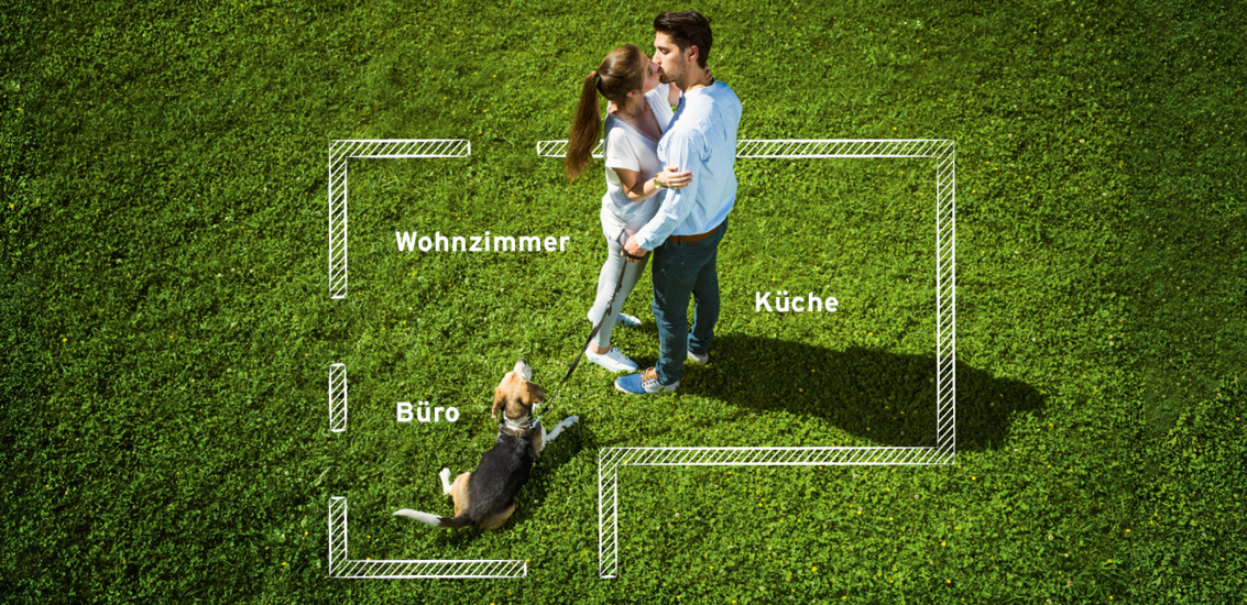 Mann und Frau küssen sich auf Wiese mit Hund und Grundriss von Haus im Hintergrund 5 Mann und Frau küssen sich auf Wiese mit Hund und Grundriss von Haus im Hintergrund 5